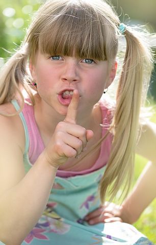 Little girl angrily shushing the camera. 